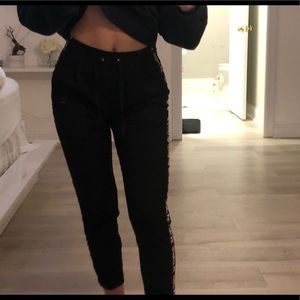 BLACK TROUSERS WITH WORDS ACROSS SIDE OF LEG